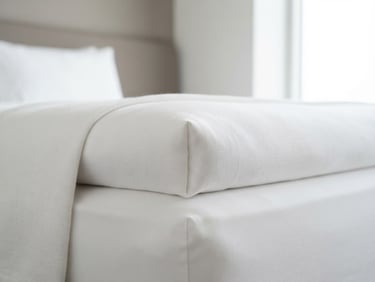 Macro shot of clean, minimalist white linen bedding, high-key natural lighting, sharp architectural angles, clinical hygiene look