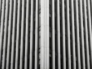 Minimalist architectural detail of a modern skyscraper facade in New York, clean lines, high contrast black and white lighting, negative space.