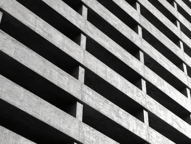 Abstract geometric lines of a modern concrete building facade, high-contrast black and white photography.