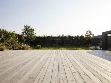 Wide architectural shot of a minimalist oak terrace overlooking a green garden in Aarhus, soft morning sun, high-contrast, 35mm lens