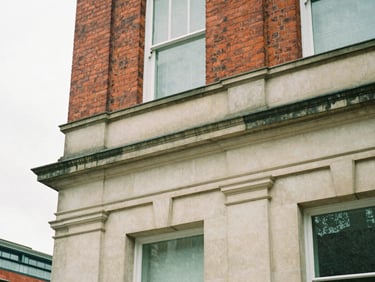 Close-up architectural detail of classic red brick and Portland stone facade in Birmingham, soft overcast daylight, clean structural lines, editorial documentary style