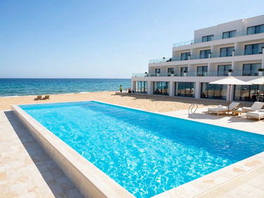 Bright coastal photography of a modern hotel pool next to a sandy beach in Mamaia, sun-drenched natural light, vibrant blue and white tones