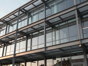 Macro architectural shot of structured steel beams and glass panels of a modern commercial facility, early morning light.