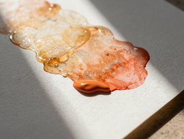 Extreme close-up of thick acrylic paint layers in amber and coral on textured watercolor paper, sharp shadows cast by warm natural sunlight, tactile art studio setting.
