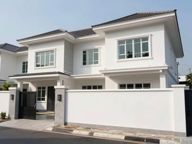 Wide daylight exterior of a completed two-storey residential compound in South Jakarta, clean white facade with concrete accent panels, entry gate visible at left third, clear sky above