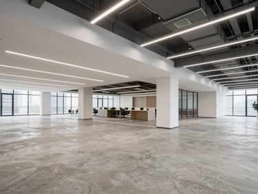 Wide-angle environmental shot of a modern commercial office interior, clean concrete floors, architectural lighting, steel beams, professional styling