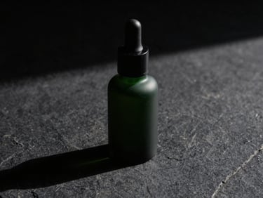 Macro shot of thick green serum in a matte black dropper bottle, low-key side-lighting, sharp geometric shadow, on a dark stone surface.