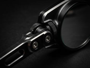 Macro close-up of a machined aluminum motorcycle rearview mirror, dramatic low-key studio lighting, metallic silver highlights, matte black background, sharp technical details