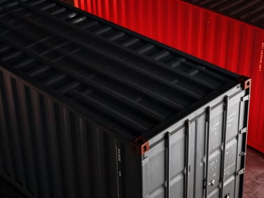 Overhead shot of a modern shipping container terminal at night, vibrant red lights, dramatic low-key studio lighting, matte black and metallic silver tones, sharp macro lens, high-contrast details