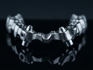 crisp macro product photography, high-contrast studio lighting, cool clinical tones, dark background, 100mm macro lens, a freshly milled titanium dental framework resting on a dark reflective surface