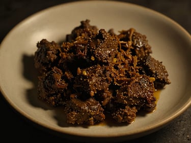 Close-up artistic shot of slow-cooked beef rendang, elegantly plated on a hand-thrown ceramic dish, moody low-key side lighting, deep shadows, warm gold and charcoal tones