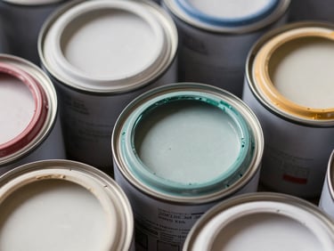 Macro shot of paint can lids stacked in a row showing color swatches on the rim, crisp overhead daylight, texture of dried paint visible on metal edges, no people