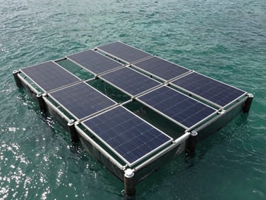 Close overhead shot of floating solar array mounted on fish cage pontoons in coastal Indonesian waters, panels angled toward sun, water surface visible between cage nets, overcast daylight with natural blue-green tones