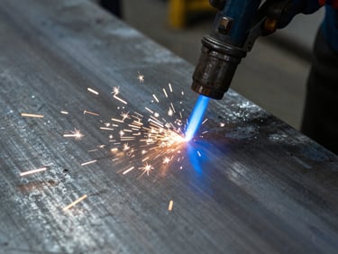 Close-up of a blue plasma arc cutting through thick steel plate, sparks flying, industrial workshop background, sharp focus, cool steel tones.