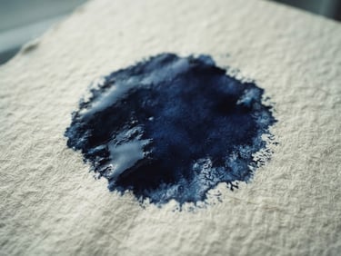 Macro shot of ink drying on textured heavy art paper, deep indigo shadows, cool natural window light, minimalist composition