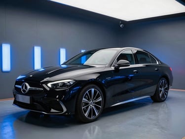 Crisp automotive photography of a modern luxury sedan inside a clean, high-tech paint booth with electric blue lighting reflections on its glossy black surface, wide angle, 35mm