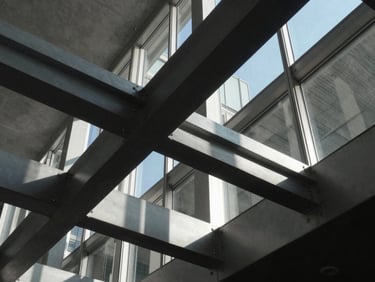 Abstract architectural geometry showing intersecting steel beams and glass, high-contrast shadows, modern minimalist aesthetic.