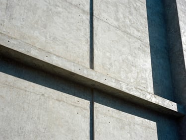Low-angle architectural shot of concrete walls with perfectly cast conduit paths, sharp shadows, cool daylight, 35mm.