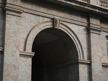 Architectural detail of a historic stone arch inside a classical Madrid building, soft natural side-lighting, elegant shadow