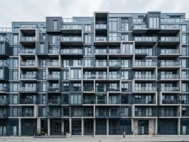 Crisp architectural photography of a modern apartment building facade, sharp geometric lines, cool desaturated blue tones, bright overcast daylight.
