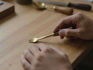 Close-up of hands polishing a brass desk tool on an oak workbench, soft directional light, shallow depth of field.