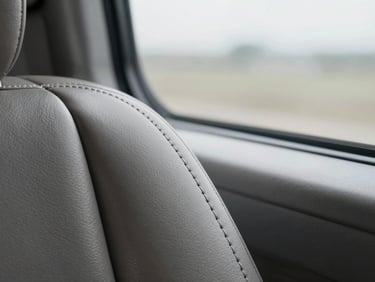 Macro detail of pristine leather stitching inside a silent executive cabin, soft overcast daylight filtering through tinted glass.