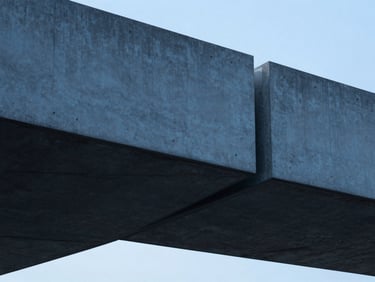 Minimalist architectural detail of a modern concrete and steel cantilevered structure, cool crisp daylight, deep sapphire and charcoal tones, sharp focus, 35mm