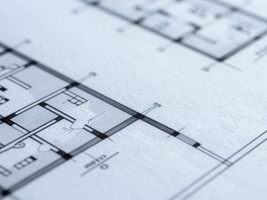Macro close-up of architectural blueprints under cool daylight, sharp focus, technical details visible.