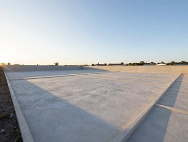Wide-angle landscape of a cleared development land lot, well-lit by soft golden hour sun, clean boundaries, sharp focus.