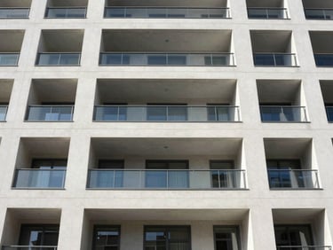 Symmetrical wide-angle architectural photograph of a modern apartment building exterior, clean concrete lines, bright natural daylight.