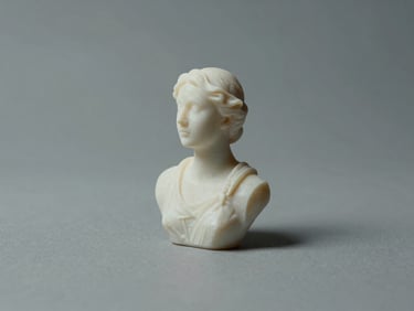 Three-quarter view of a jewellery wax model on a neutral matte surface, cool studio strobe lighting, form and surface shadow clearly defining the carved geometry, no hands, no people, straight-on framing with deliberate negative space