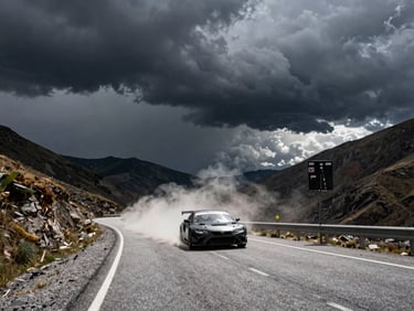 Dark dramatic storm clouds over mountain pass road, high-contrast natural light, moody atmosphere