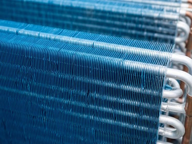 Crisp commercial photography, close-up of pristine aluminum condenser coils with specialized blue anti-corrosion coating, bright Florida daylight, 35mm