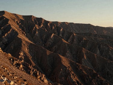 Wide panoramic low-angle shot of a raw mountain plateau at golden hour, deep shadows, sharp ridgelines, medium format film.