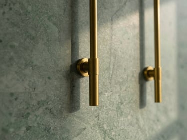 Close-up of hand-brushed brass fixtures against a raw travertine marble wall, soft golden hour lighting, 35mm