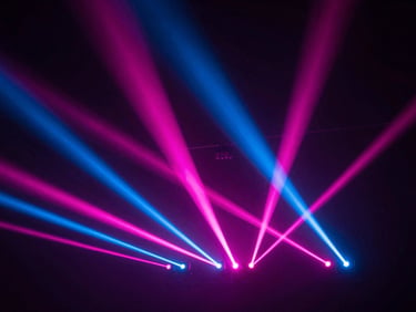 Dynamic low-angle shot of robotic stage lights shooting sharp pink and blue laser beams through light haze, dark background