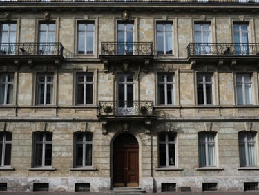 Wide shot of a classic Geneva residential building façade at street level, stone details under even overcast daylight, architectural framing, no people