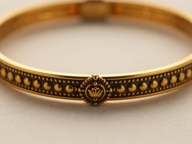 Macro shot of a 22kt gold bangle with traditional South Indian temple jewelry design, warm directional light, rich champagne tones, extreme close-up.