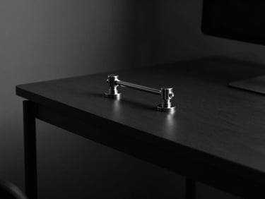 Minimalist workspace with premium metallic hardware on a dark desk, soft light from the side, deep shadows