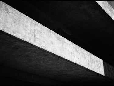 Stark monochrome architectural detail of a concrete cantilever structure, sharp shadows, dramatic low-key lighting, 35mm film