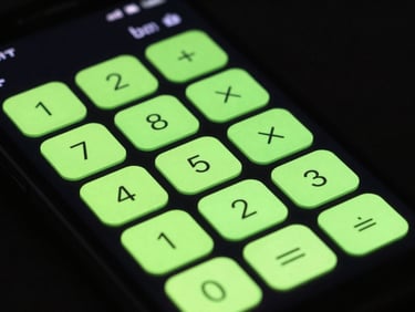 Close-up of a physical Android phone displaying a sleek calculator app with neon green buttons, high-contrast studio lighting