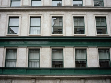 Architectural detail of a classic London building facade, structured lines, deep green accent, overcast daylight, 35mm editorial film photography.