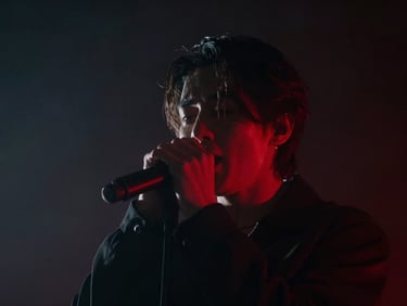 Moody music video scene, singer performing under a sharp red backlight in a dark smoky studio, extreme close-up