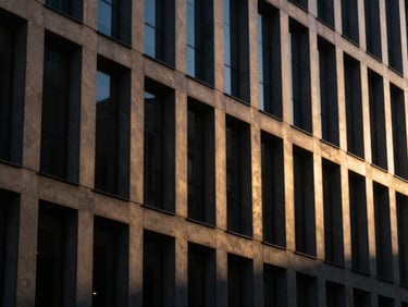 Dramatic architectural detail of a modern commercial building facade, deep shadows, reflecting golden hour light.