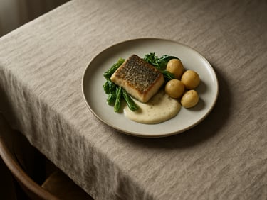 Tight overhead of a plated Nordic-style dish on a linen tablecloth, natural window light from the left, shadows soft and long, empty chair visible at the table edge