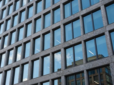 Crisp architectural detail of a modern corporate office building in Delaware, sharp geometric windows reflecting bright blue sky, daylight.