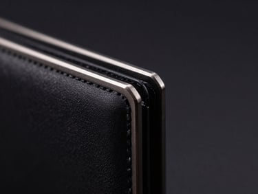 Extreme close-up of a CNC-milled black metal wallet edge, showing the precise metallic chamfers and matte anodized texture under low-key studio lighting.
