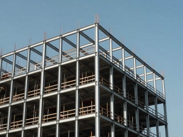 Structure métallique géométrique d'un bâtiment en construction sous un ciel bleu clair, lignes épurées et cadrage structuré.