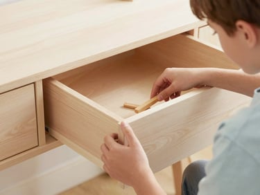 Close-up of a teen assembling a desk drawer with a simple tool, showing clean wood joints, natural daylight, soft shadows, 35mm lens.
