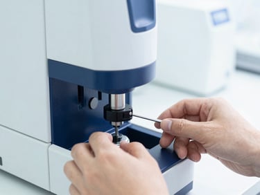 Close-up of technical hands calibrating high-precision laboratory analyzer, bright high-key studio lighting, sterile white and deep blue tones, sharp focus, 50mm